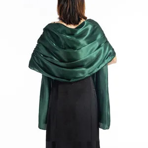 Back view of emerald green satin shawl draped over an elegant black evening dress