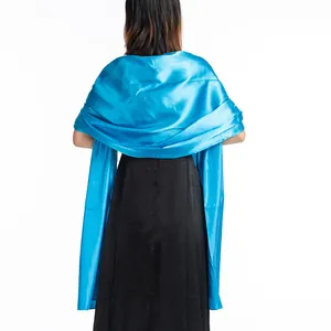 Back view of a shimmering blue satin shawl draped over an elegant black evening dress.