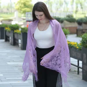 Close-up of purple lace shawl with elegant floral embroidery and fringes on a model