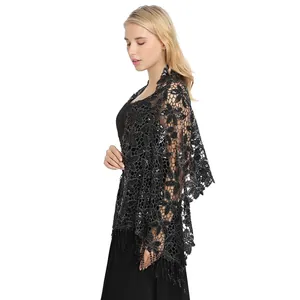 Close-up detail of a elegant black lace sequin shawl with fringe tassels on a model.