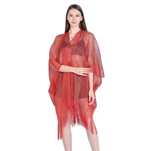 Close-up detail of a red shimmery metallic mesh poncho with fringe for bikini cover up
