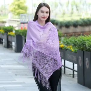 Elegant lavender lace shawl with floral embroidery and fringes worn by a model outdoors.