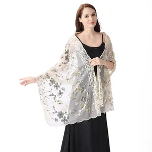 Detail of a white mesh shawl with elegant floral gold sequins for evening gowns.