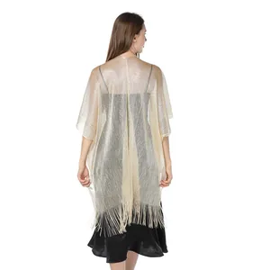 Back view showing the shimmering gold metallic yarn texture and fringe trim of this elegant shawl