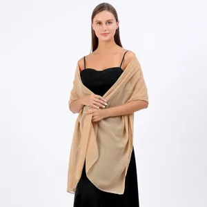 Élégant châle en mousseline champagne gracieusement drapé sur une robe de soirée noire