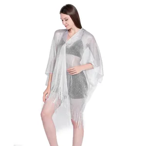 Detail of silver metallic mesh shawl with fringe trim, worn as a bikini cover-up.