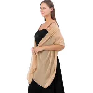 Détail d'un châle en mousseline champagne élégamment drapé pour une tenue de soirée
