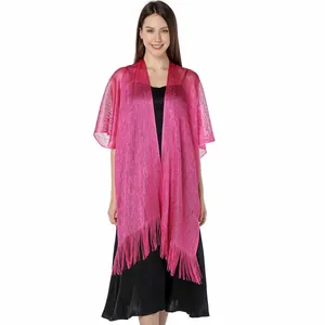 Full view of pink shimmering metallic shawl with elegant fringe detail on model