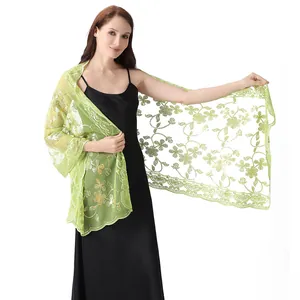 Detailed view of light green sheer shawl with floral sequin embroidery on black dress