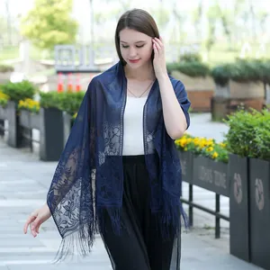 Elegant navy blue lace shawl scarf with floral patterns and fringes on a model