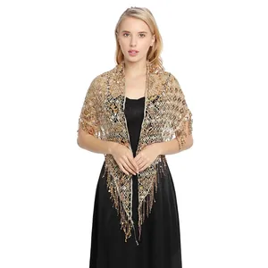 Elegant gold sequined shawl wrap with hanging tassels styled on a model with black dress