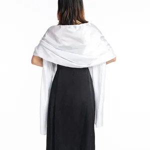 Detail view of a luxurious white satin shawl wrapped over a black evening dress back.