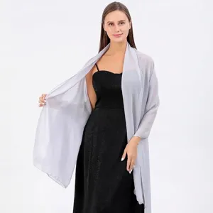 Élégant châle de soirée en mousseline argentée sur une robe noire formelle pour mariage.