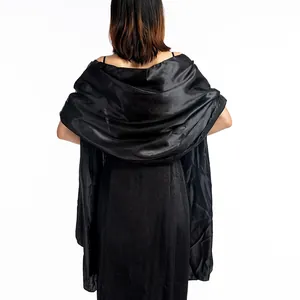 Detail showing back drape of black satin shawl for evening dress with satin finish.