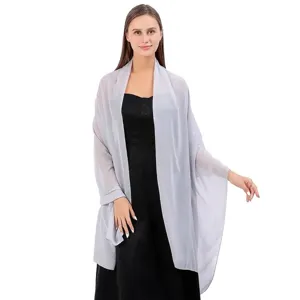 Châle en mousseline argentée drapé sur une robe de soirée noire élégante