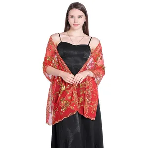 Detailed view of red lace bridal shawl with gold floral embroidery and sequins