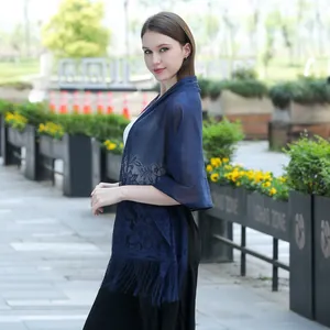 Detailed shot of elegant navy blue lace shawl with fringe for bridal and evening wear