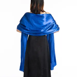 Back view of elegant royal blue satin shawl draped over a black formal evening gown