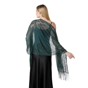 Back view of a dark green hollow lace shawl with floral patterns and long tassels.