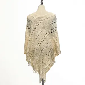 Detailed view of a cream-colored knitted pullover shawl with intricate patterns and fringe trim