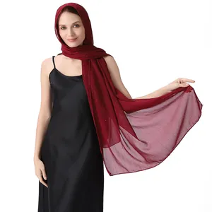 Close-up of elegant burgundy chiffon shawl with sparkling rhinestones and silver threads