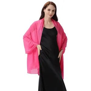 Leuchtend rosa Chiffon-Schal mit funkelnden Strasssteinen über einem schwarzen Abendkleid