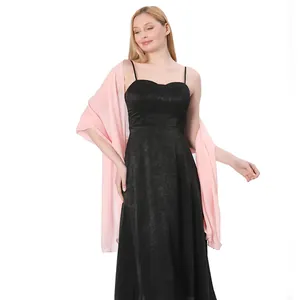 Detailed view of light pink chiffon wrap shawl paired with black evening dress