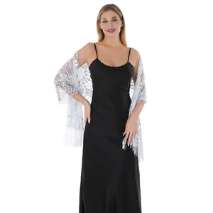 Elegant silver sequin embroidered shawl wrap with tassels worn over a black dress