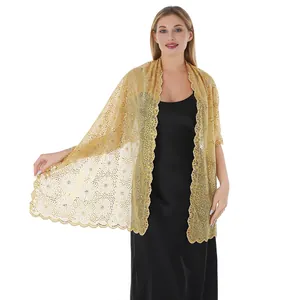Elegant gold sequined lace shawl with floral embroidery worn over a black dress.