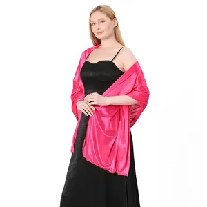 A model showcasing a vibrant hot pink satin evening shawl draped over a black dress