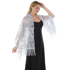 Elegant silver sequined peacock shawl with fringe details over black evening dress