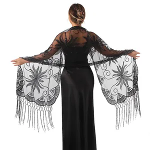 Détail d'un châle noir brodé de fleurs en paillettes avec de longues franges soyeuses