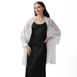 Full length view of elegant white sheer shiny silk crepe shawl draped over a black slip dress