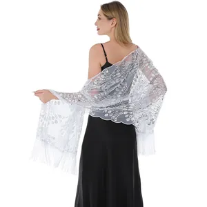 Detail view of elegant white mesh shawl with silver sequins and long fringe.