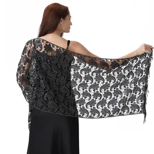 Close-up detail view of black sequined lace shawl with delicate paisley pattern.