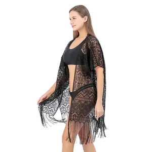 Gedetailleerd zijaanzicht van zwarte kant strand cover-up met geometrische patronen en franjes.