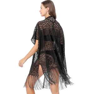 Detailweergave van zwarte kanten strand-cover-up met geometrische patronen en franjes