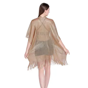 Detail view of a sparkling gold metallic fringe shawl beach cover-up with open sleeves