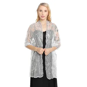 Detail view of an elegant white sequined lace shawl perfect for bridal or evening wear.