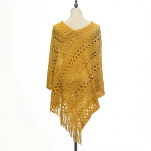 Detailed close-up of a yellow knitted hollow-out poncho with elegant long fringe hem