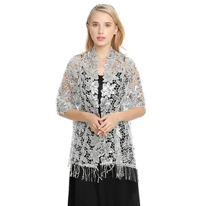 Detail view of a silver floral lace shawl with sequins and elegant tassels for evening wear