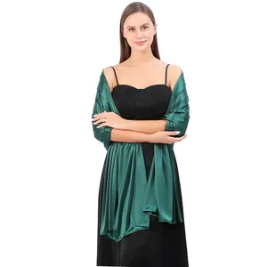 Full view of elegant dark green satin evening shawl styled over a black evening dress