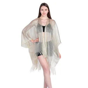 Elegant gold metallic mesh shawl with long tassels worn as a stylish bikini cover-up