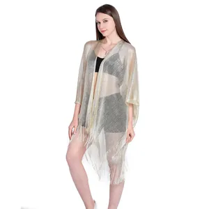 Detail view showing the metallic lurex texture and elegant fringe tassels of this gold shawl