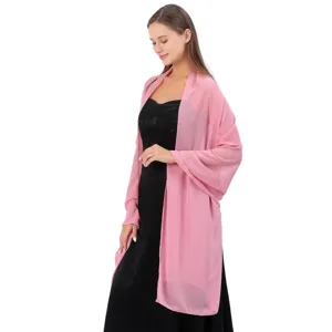 Vue détaillée d'un châle en mousseline rose drapé sur une robe de soirée noire élégante.