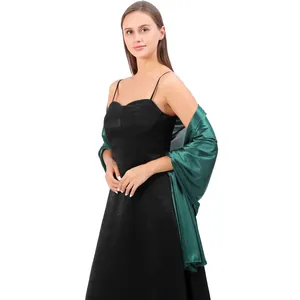 Elegant dark green satin evening shawl draped over a stylish black formal cocktail dress