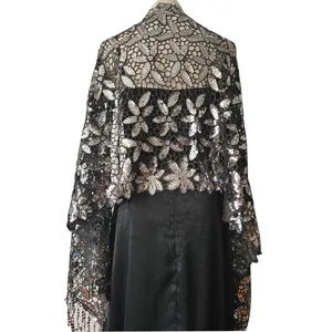 Exquisite detail of elegant black lace evening shawl featuring silver floral sequins and tassels