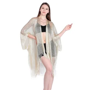 Detailed view of the gold metallic thread fabric on a sheer fringe holiday cover-up.