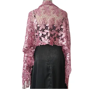 Detailed back view of a pink sequined lace shawl with tassels worn over a black evening dress