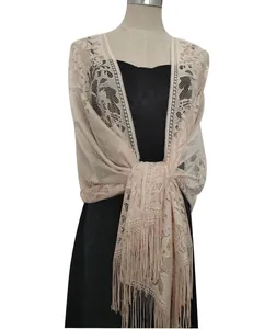 Detailed view of an elegant beige hollow-out lace shawl featuring long tassel fringe
